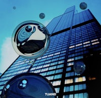 a group of blue bubbles in front of a skyscraper